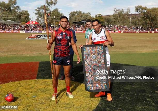 Neville Jetta of the Demons and Eddie Betts of the Crows exchange gifts during the 2018 AFL round 10 match between the Melbourne Demons and the...