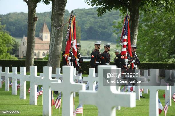 Marines bear flags as they walk past the graves of U.S. Soldiers, most of them killed in the World War I Battle of Belleau Wood, before a ceremony to...