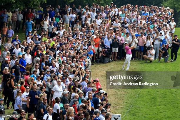 Crowds watch as Rory McIlroy of Northern Ireland plays his second shot on the 1st hole during day four and the final round of the BMW PGA...