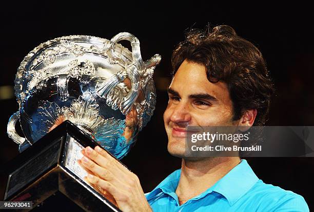 Roger Federer of Switzerland holds aloft the Norman Brookes Challenge Cup after his men's final match against Andy Murray of Great Britain during day...