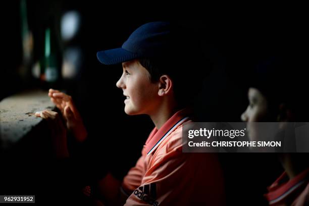 Ballboys watch as Japan's Kei Nishikori serves to France's Maxime Janvier during their men's singles first round match on day one of The Roland...