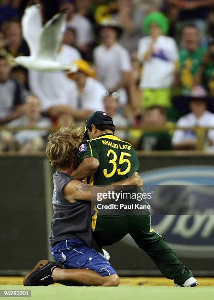 Pitch invader tackles Khalid Latif of Pakistan during the fifth One Day International match between Australia and Pakistan at WACA on January 31,...