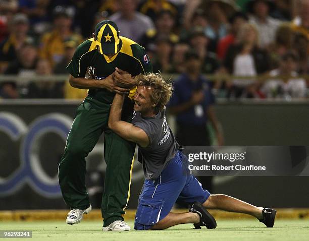 Khalid Latif of Pakistan is tackled by a spectator during the fifth One Day International match between Australia and Pakistan at WACA on January 31,...