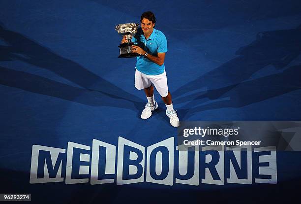 Roger Federer of Switzerland holds aloft the Norman Brookes Challenge Cup after his men's final match against Andy Murray of Great Britain during day...