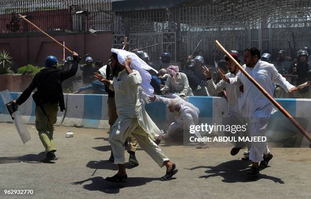 Activists of the Jamiat Ulema-e-Islam-Fazl party run from policemen during a protest against the amendment bill on semi-autonomous Federally...