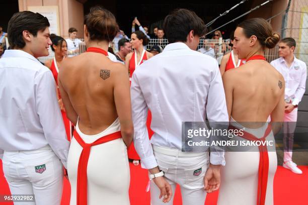 Grid girls and boys stand along the red carpet for the pit lane walk ahead of the Monaco Formula 1 Grand Prix at the Monaco street circuit on May 27,...