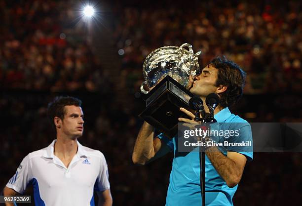 Roger Federer of Switzerland kisses the Norman Brookes Challenge Cup as Andy Murray of Great Britain looks on after the men's final match during day...