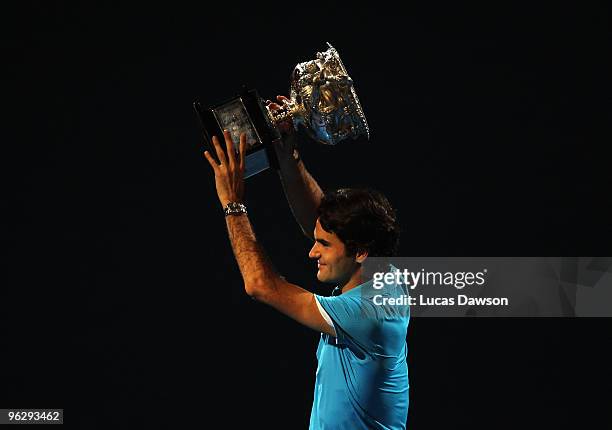 Roger Federer of Switzerland holds aloft the Norman Brookes Challenge Cup after his men's final match against Andy Murray of Great Britain during day...