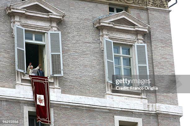 Pope Benedict XVI flanked by two children of the Italian Association 'Azione Cattolica' delivers his Sunday angelus blessing from the window of his...