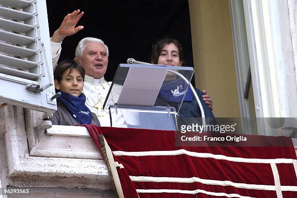 Pope Benedict XVI flanked by two children of the Italian Association 'Azione Cattolica' delivers his Sunday angelus blessing from the window of his...