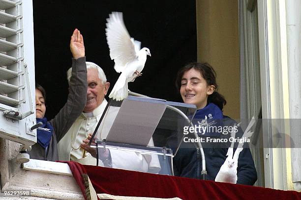 Pope Benedict XVI and two children of the Italian Association 'Azione Cattolica' free two doves as a symbol of peace at the end of his sunday angelus...