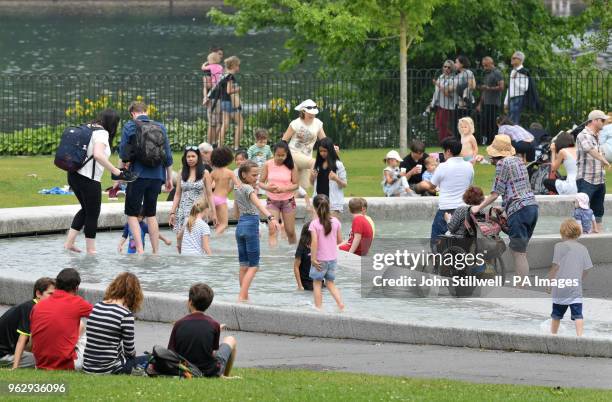 People cool off in the Diana Memorial Fountain in Hyde Park, London.