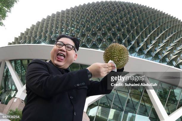 Kim Jong Un impersonator, Howard X poses with a Singapore local fruit, the durian at Esplanade on May 27, 2018 in Singapore. The proposed North...