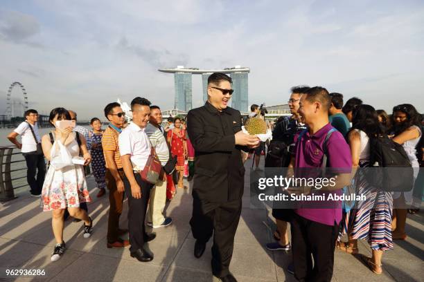 Kim Jong Un impersonator, Howard X holds the durian as he interacts with tourists at Merlion Park on May 27, 2018 in Singapore. The proposed North...