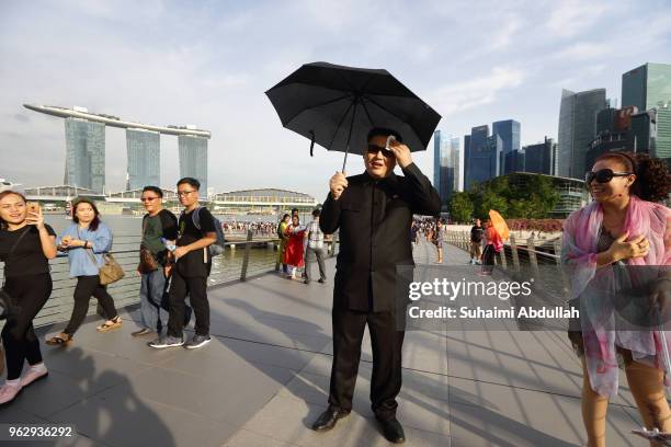 Kim Jong Un impersonator, Howard X walks along the Jubilee Bridge as he makes an appearance at Marina Bay on May 27, 2018 in Singapore. The proposed...