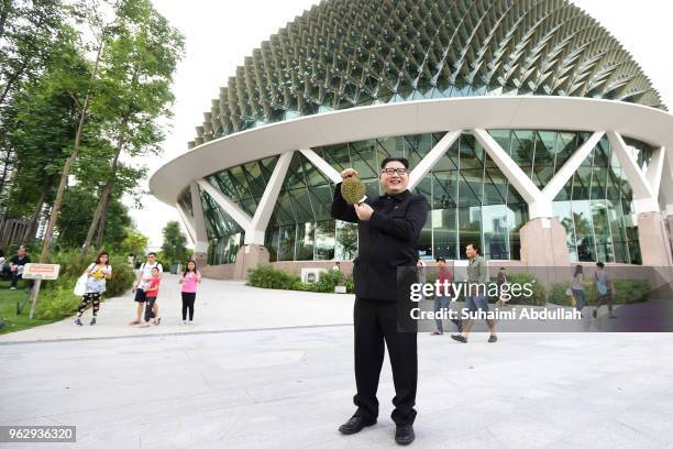 Kim Jong Un impersonator, Howard X poses with a Singapore local fruit, the durian at Esplanade on May 27, 2018 in Singapore. The proposed North...