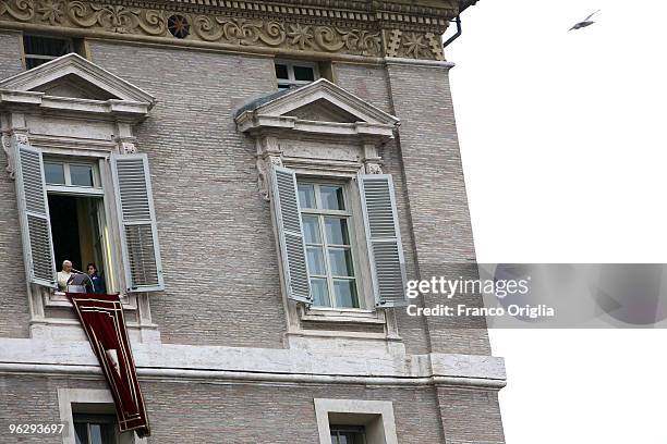 Pope Benedict XVI flanked by two children of the Italian Association 'Azione Cattolica' delivers his Sunday angelus blessing from the window of his...