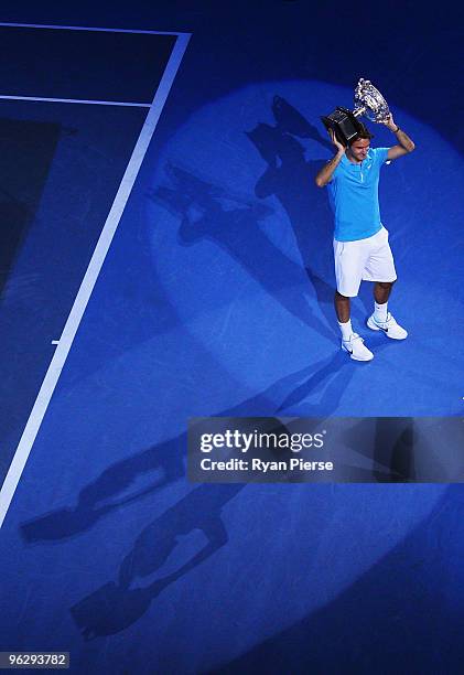 Roger Federer of Switzerland holds aloft the Norman Brookes Challenge Cup after his men's final match against Andy Murray of Great Britain during day...