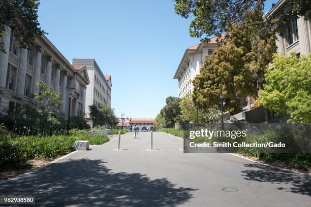 Students walk through a shaded footpath on a sunny day on the main campus of UC Berkeley in downtown Berkeley, California, May 21, 2018.