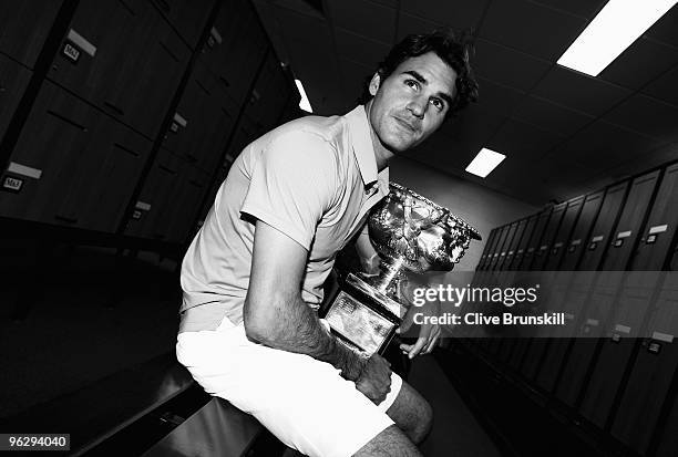 Roger Federer of Switzerland poses with the Norman Brookes Challenge Cup in the players locker room after winning the men's final match against Andy...