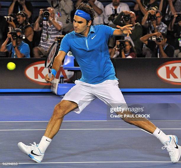 Roger Federer of Switzerland hits a volley return against Andy Murray of Britain in their men's singles final on day 14 of the Australian Open tennis...