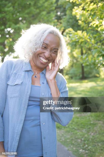 senior woman outside laughing - undershirt stock pictures, royalty-free photos & images