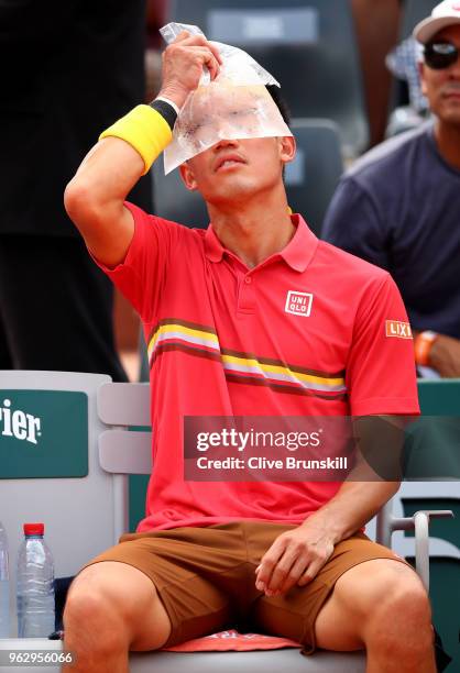 Kei Nishikori of Japan cools down with an ice-bag during his mens singles first round match against Maxime Janvier of France during day one of the...