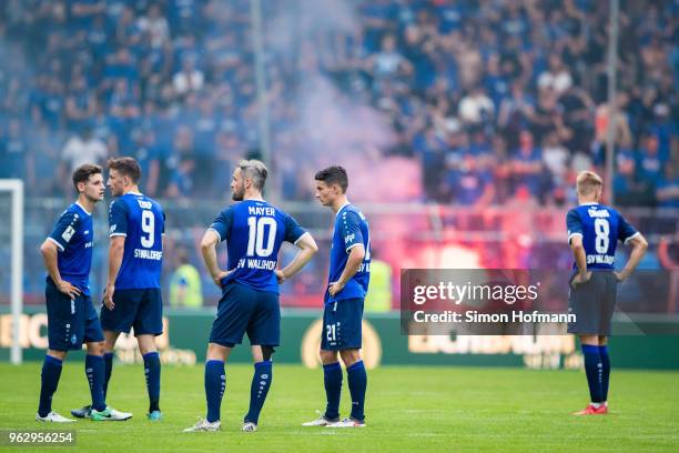 Team mates of Mannheim react as their supporters light fireworks during the Third League Playoff Leg 2 match between SV Waldhof Mannheim and KFC...