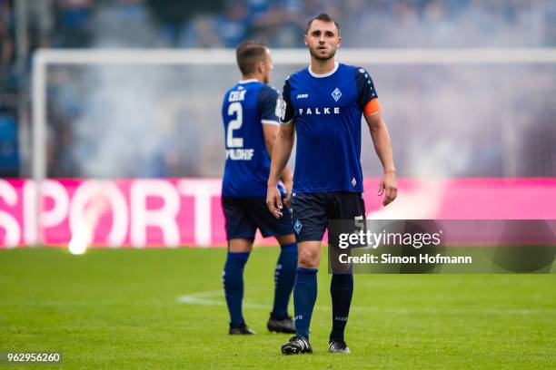 Team mates of Mannheim react as their supporters light fireworks during the Third League Playoff Leg 2 match between SV Waldhof Mannheim and KFC...