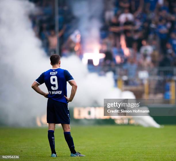 Benedikt Koep of Mannheimreacts as supporters of his team light fireworks during the Third League Playoff Leg 2 match between SV Waldhof Mannheim and...