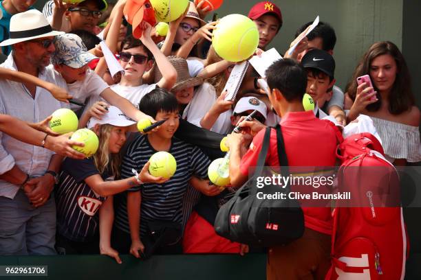 Kei Nishikori of Japan signs autographs following his mens singles first round match against Maxime Janvier of France during day one of the 2018...