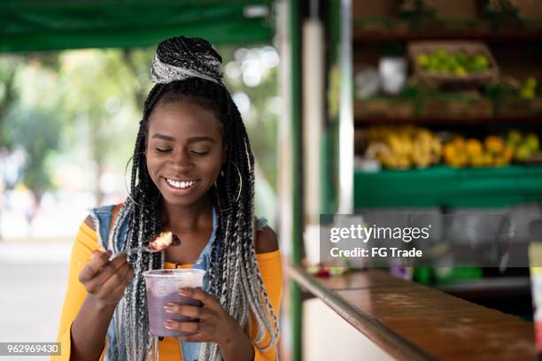 brazilian girl eating açai acai bowl - acai berry stock pictures, royalty-free photos & images