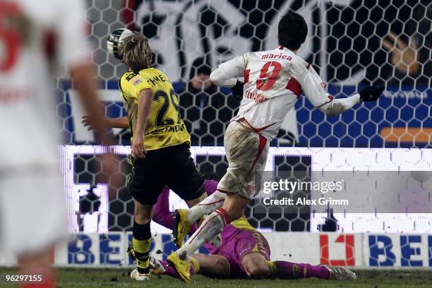 Ciprian Marica of Stuttgart scores his team's third goal against goalkeeper Marc Ziegler and Marcel Schmelzer of Dortmund during the Bundesliga match...