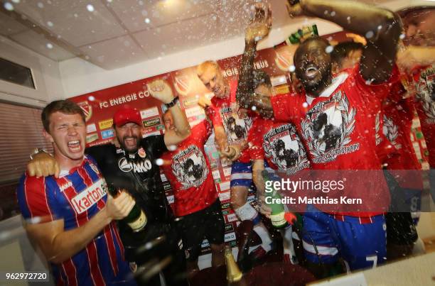 Head coach Claus Dieter Wollitz and his players celebrate after moving up into the third league after the Third League Playoff Leg 2 match between FC...