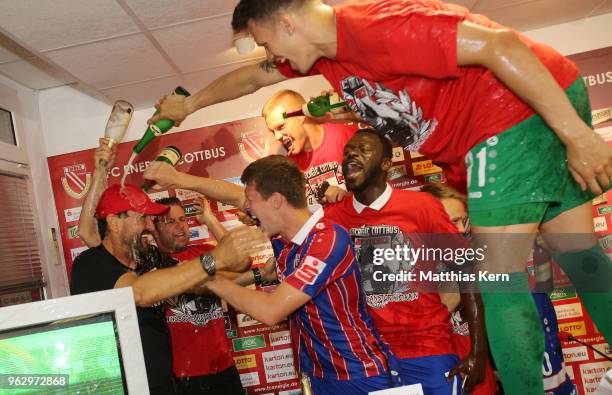 Head coach Claus Dieter Wollitz of Cottbus and his players celebrate after moving up into the third league after the Third League Playoff Leg 2 match...