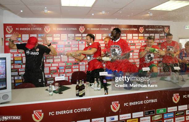 Head coach Claus Dieter Wollitz of Cottbus gets an beer and champagner shower after moving up into the third league after the Third League Playoff...
