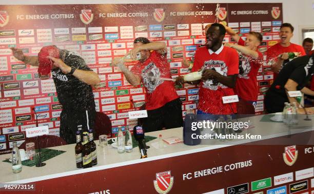 Head coach Claus Dieter Wollitz of Cottbus gets an beer and champagner shower after moving up into the third league after the Third League Playoff...