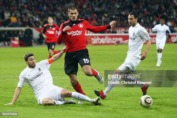 Heiko Butscher of Freiburg tackles Eren Derdiyok of Leverkusen during the Bundesliga match between Bayer Leverkusen and SC Freiburg at the BayArena...