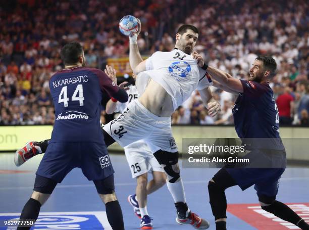 Vuko Borozan of Vardar is challenged by Nikola Karabatic and Luka Karabatic of Paris during the EHF Champions League Final 4 third place match...