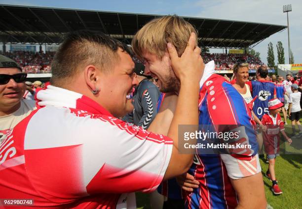 Marc Stein of Cottbus celebrates with supporters after moving up into the third league after the Third League Playoff Leg 2 match between FC Energie...