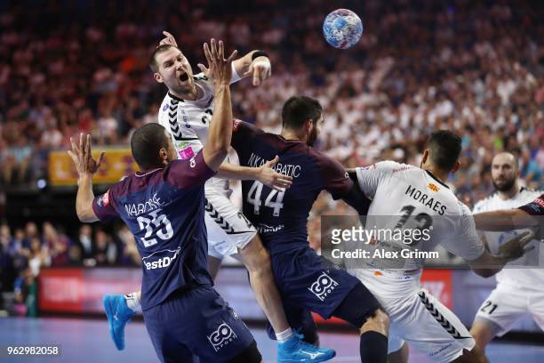 Ivan Cupic of Vardar is challenged by Daniel Narcisse and Nikola Karabatic of Paris during the EHF Champions League Final 4 third place match between...