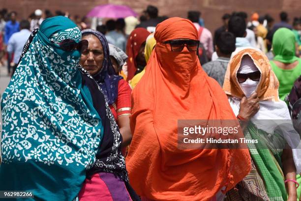 Women cover their faces to protect themselves from the scorching heat at Red Fort, on May 27, 2018 in New Delhi, India. The mercury in the capital...