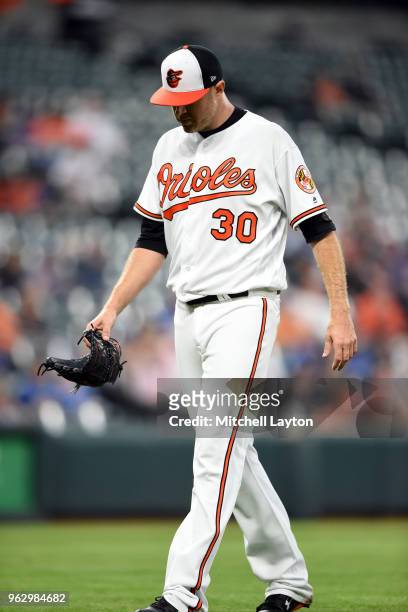 Chris Tillman of the Baltimore Orioles walks back to the dug out during a baseball game against the Kansas City Royals at Oriole Park at Camden on...