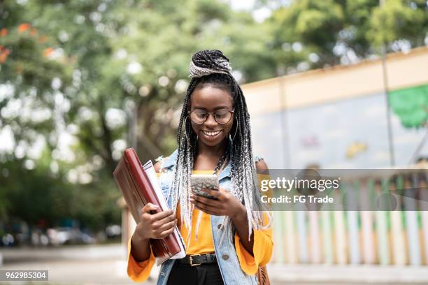 afro student/teacher on the move with mobile - africa mobile stock pictures, royalty-free photos & images