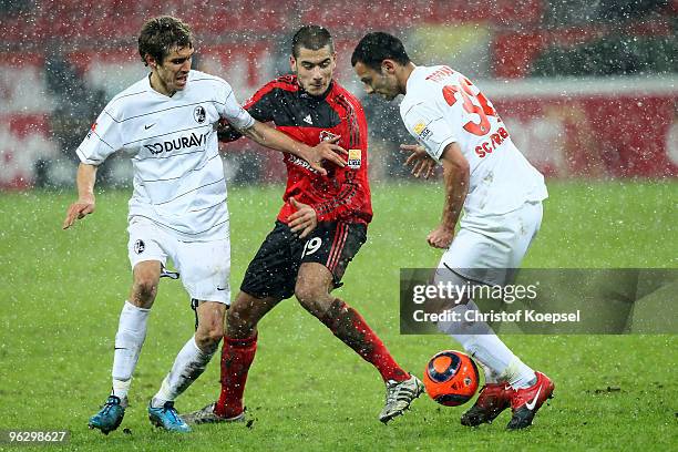 Johannes Flum of Freiburg and Oemer Toprak of Freiburg tackles Eren Derdiyok of Leverkusen during the Bundesliga match between Bayer Leverkusen and...