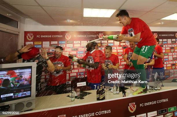 Head coach Claus Dieter Wollitz of Cottbus gets an beer and champagner shower after moving up into the third league after the Third League Playoff...