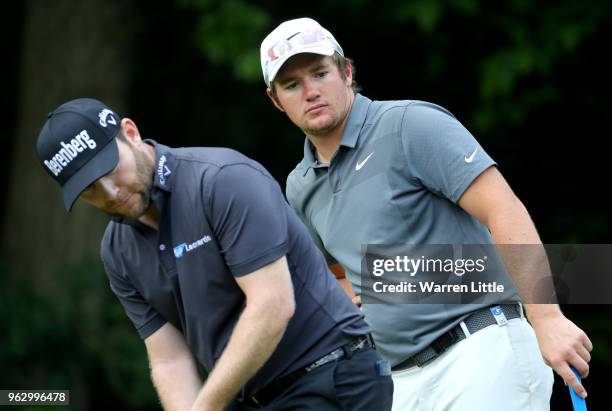 Branden Grace of South Africa and Sam Horsfield of England watch a putt during day four and the final round of the BMW PGA Championship at Wentworth...