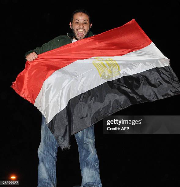 An Egyptian man holds his national flag as he celebrates in Cairo after Egypt won the 2010 African Cup of Nations in Angola on January 31, 2010....