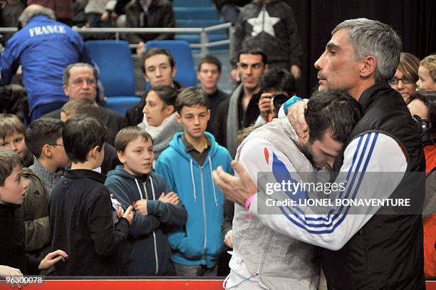 France's Erwan Lepechoux is comforted by his coach Stephane Marcellin after the Men's International Paris' Challenge Epee competition, on January 31,...