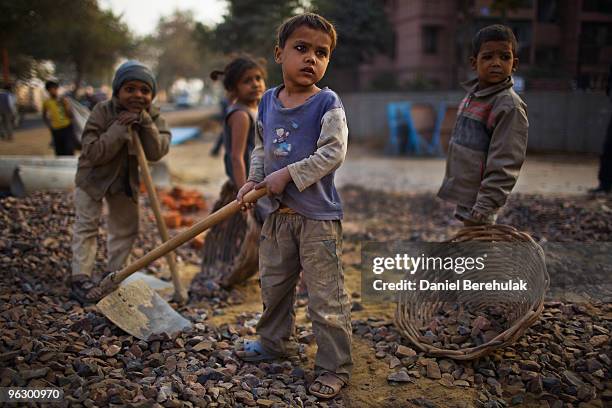 Indian children work nearby to their parents at a construction project in front of the Jawaharlal Nehru Stadium on January 30, 2010 in New Delhi,...